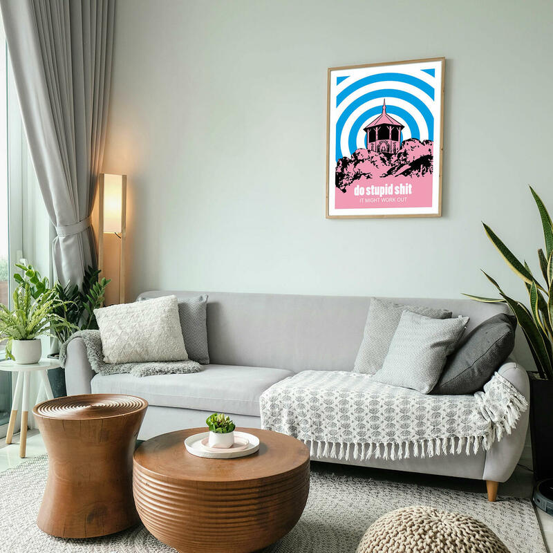 Wohnzimmer mit beigem Sofa und Beistelltischen aus Holz. An der Wand hängt ein buntes Bild, das den Grafensprung im Murgtal zeigt