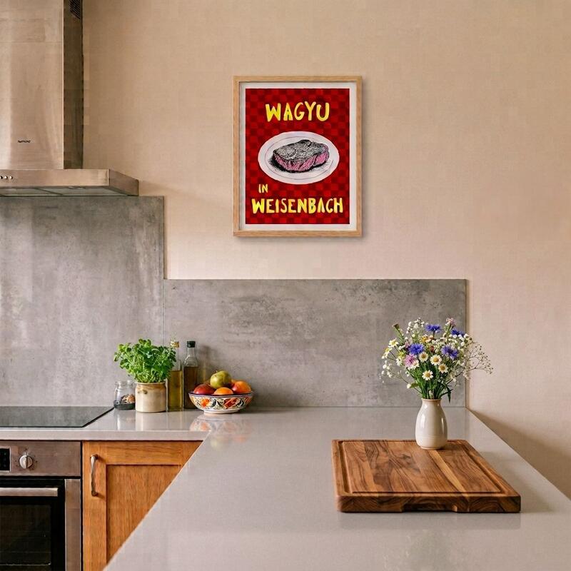 Blick in eine Küche mit einer grauen Arbeitsfläche, einem Blumenstraße auf der Arbeitsfläche und einem Poster an der Wand. Auf dem Poster steht "Wagyu in Weisenbach"